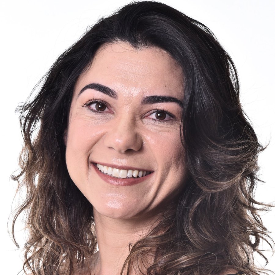 Alessandra Amado, psicóloga, em retrato sobre fundo claro, sorrindo